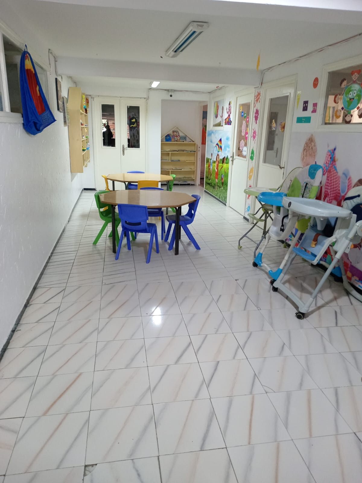 Espace d'activités avec tables et chaises hautes pour les tout-petits