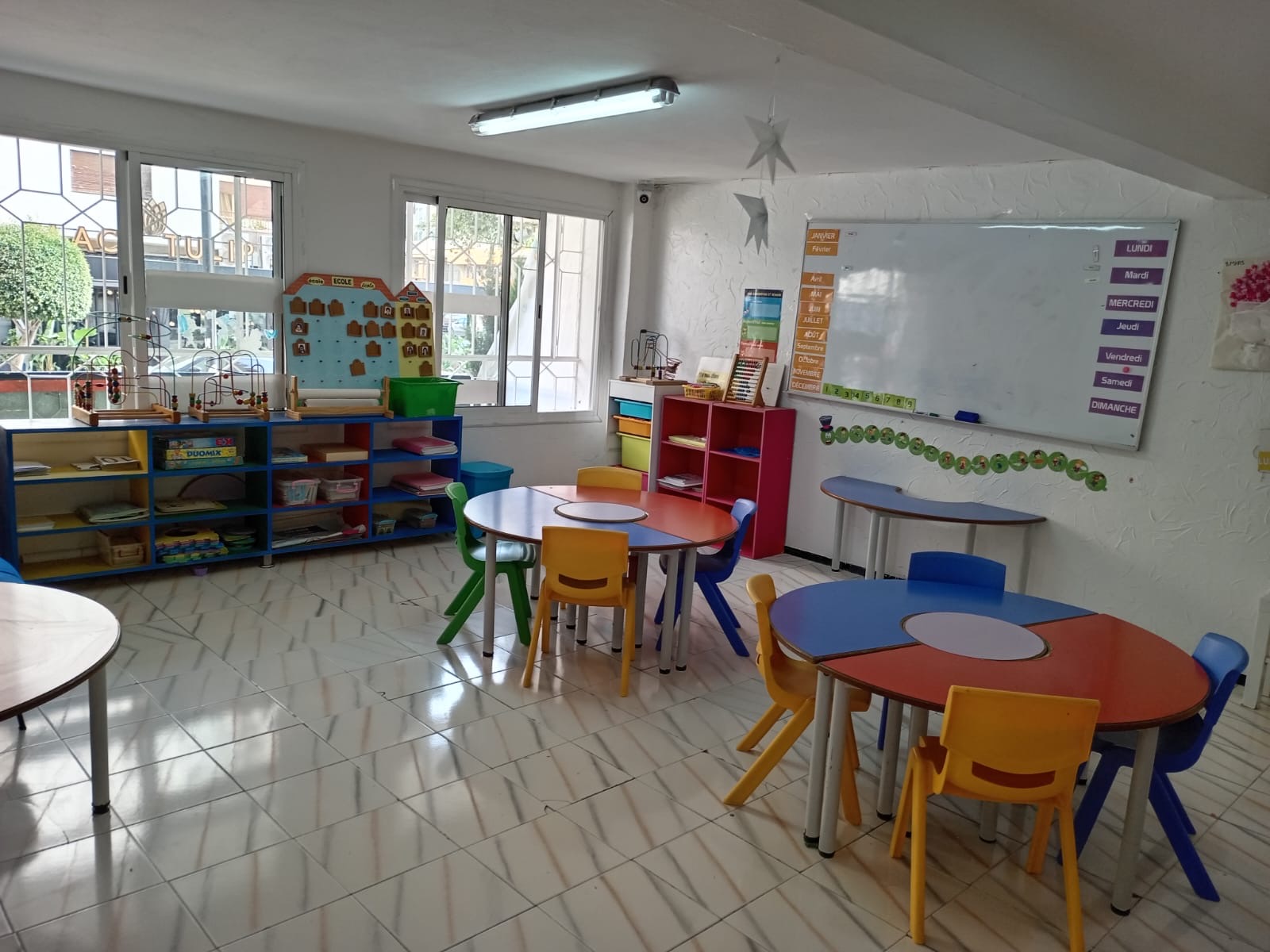 Espace de jeu libre avec cuisinette, canapé et sol en lettres de l'alphabet