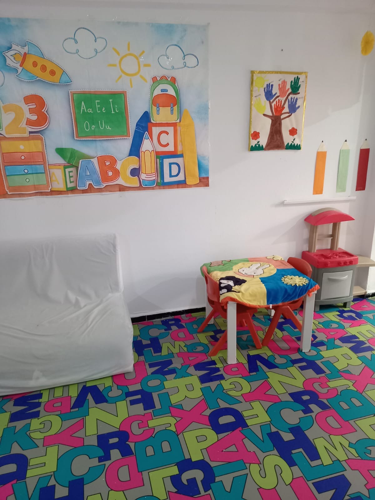 Salle de jeux au sol en tapis-puzzle, avec jouets et coin lecture
